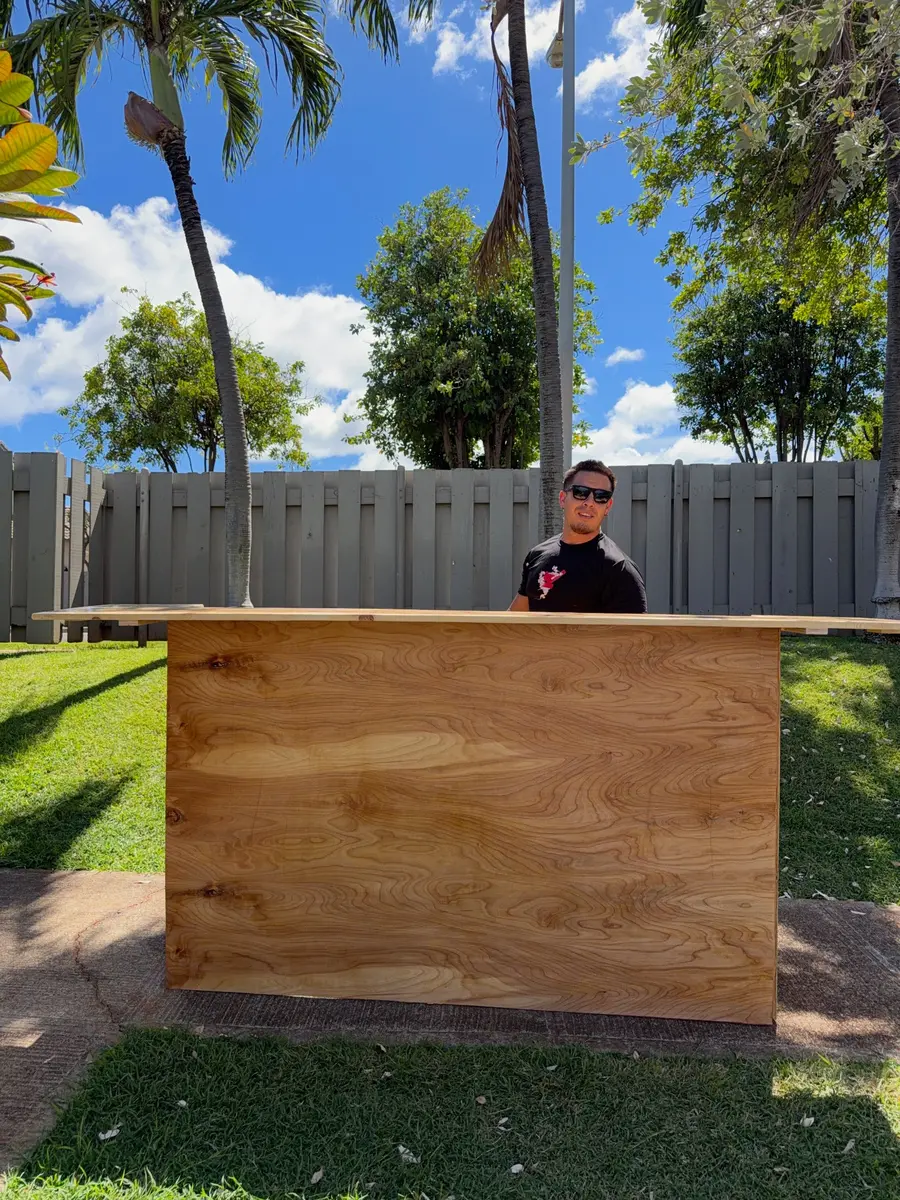Matt Perry standing behind the wooden mobile bar he brings to events